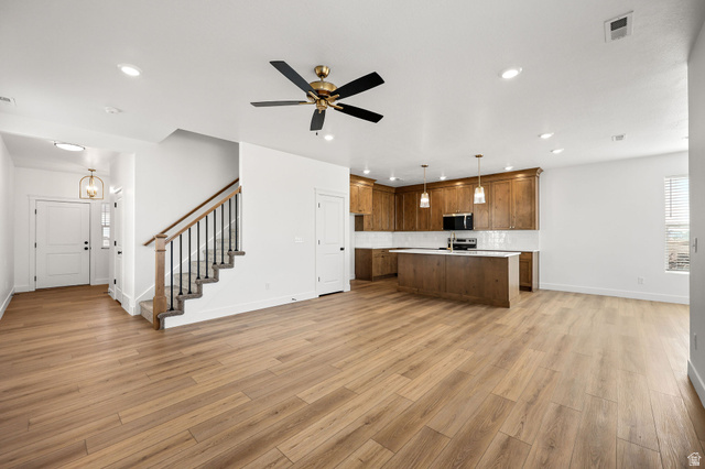 1661 West Ross Road Syracuse, UT 84075 - Photo 27 of 28 Kitchen with open floor plan, wood finish cabinets, pendant lighting, a kitchen island with sink, and a ceiling fan