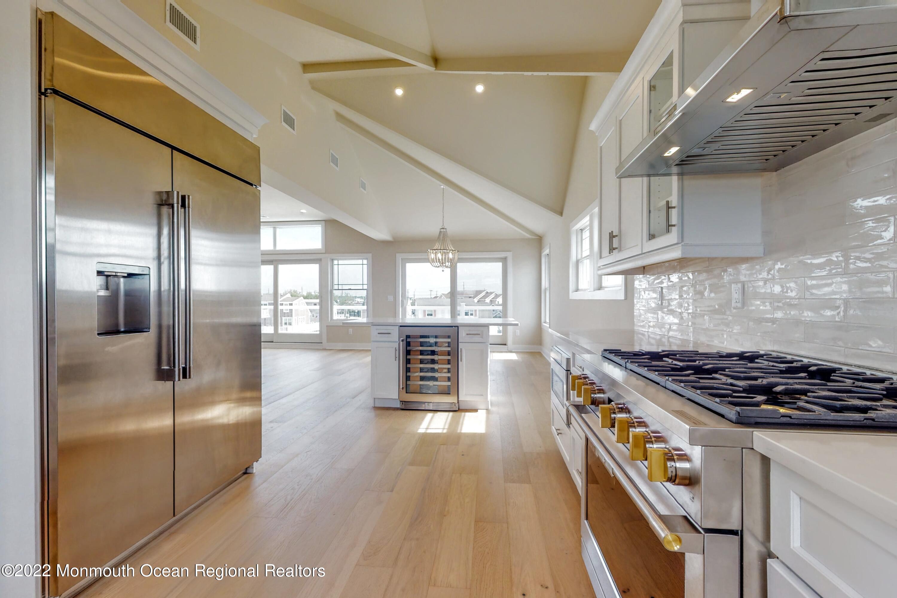 48 Muriel Drive Manahawkin, NJ 08050 - Photo 21 of 89 a kitchen with stainless steel appliances granite countertop a stove a refrigerator a sink dishwasher and white cabinets with wooden floor