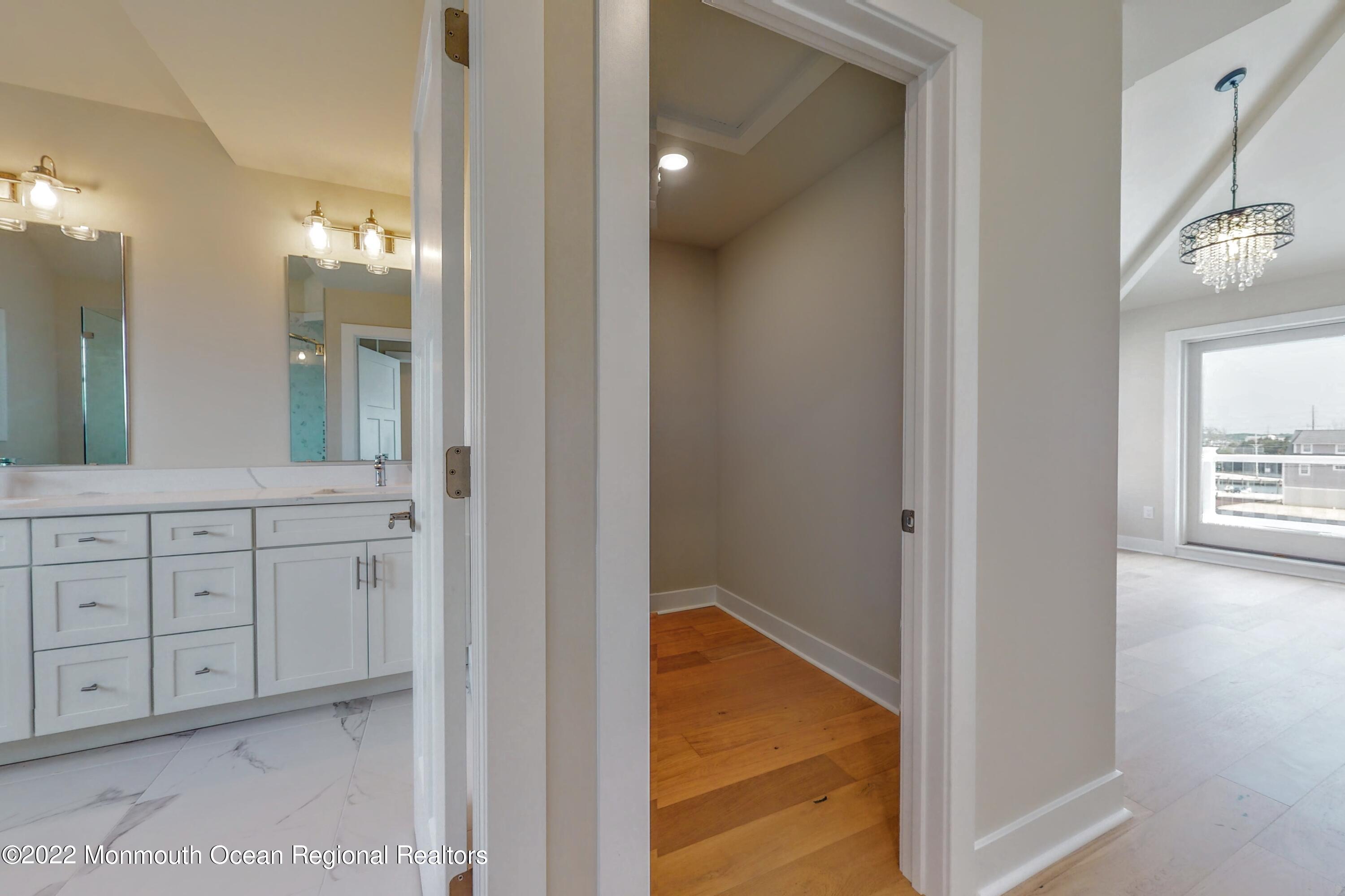 48 Muriel Drive Manahawkin, NJ 08050 - Photo 30 of 89 a spacious bathroom with a granite countertop sink a mirror and a vanity