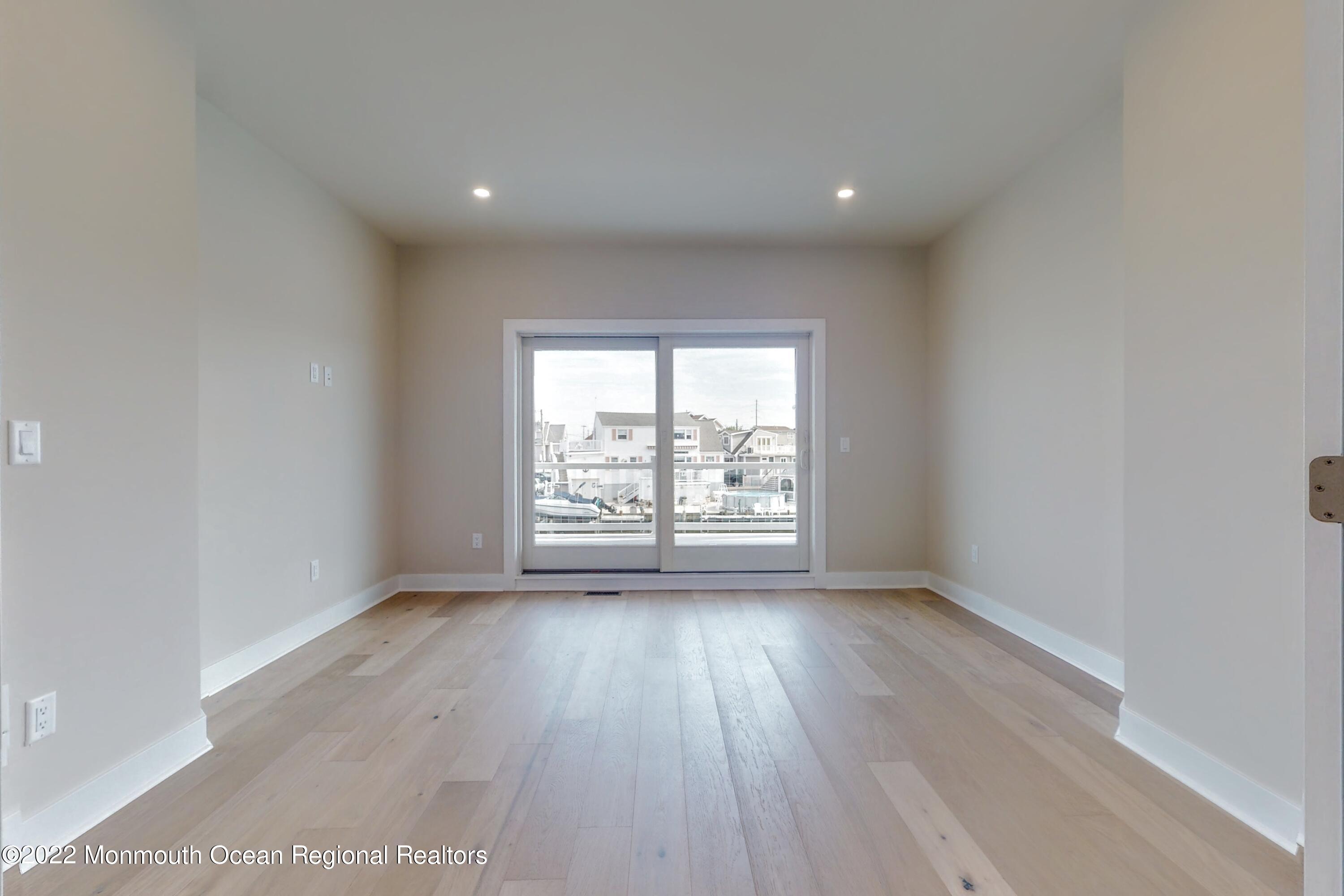 48 Muriel Drive Manahawkin, NJ 08050 - Photo 42 of 89 a view of an empty room with wooden floor and a window