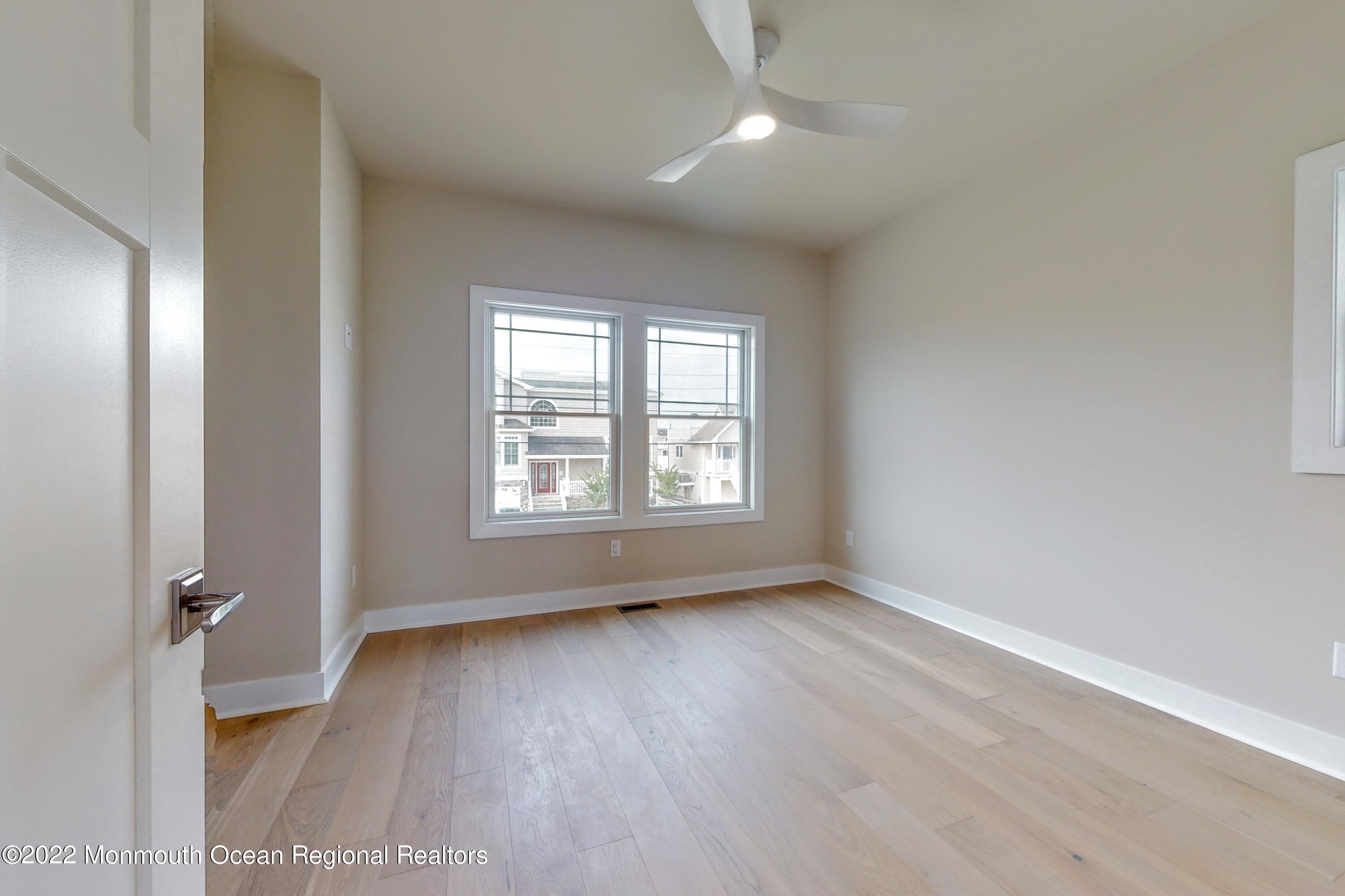 48 Muriel Drive Manahawkin, NJ 08050 - Photo 55 of 89 an empty room with wooden floor and windows