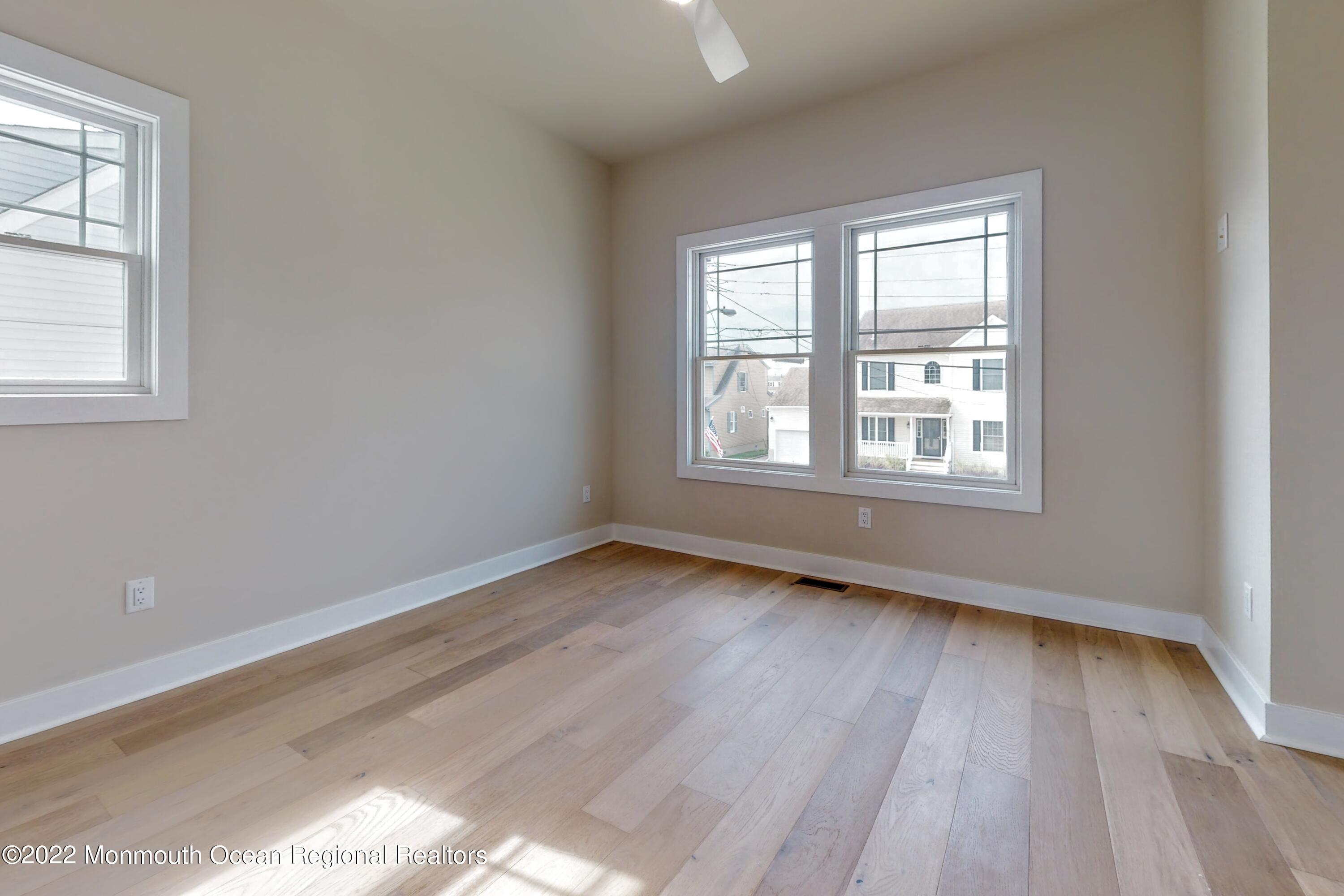 48 Muriel Drive Manahawkin, NJ 08050 - Photo 75 of 89 an empty room with wooden floor and windows