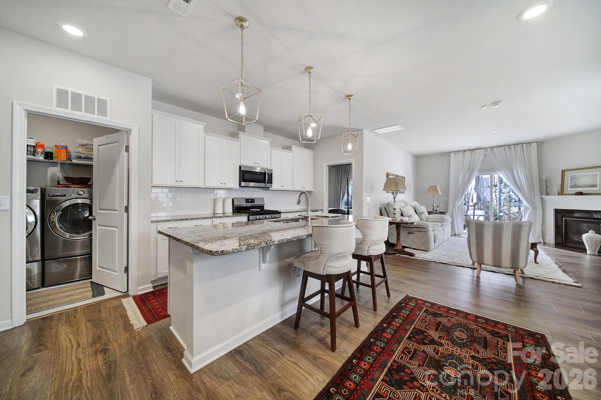 6521 Gopher Road Lancaster, SC 29720 - Photo 6 of 45 a open kitchen with stainless steel appliances granite countertop a stove top oven a sink a dining table and chairs with wooden floor