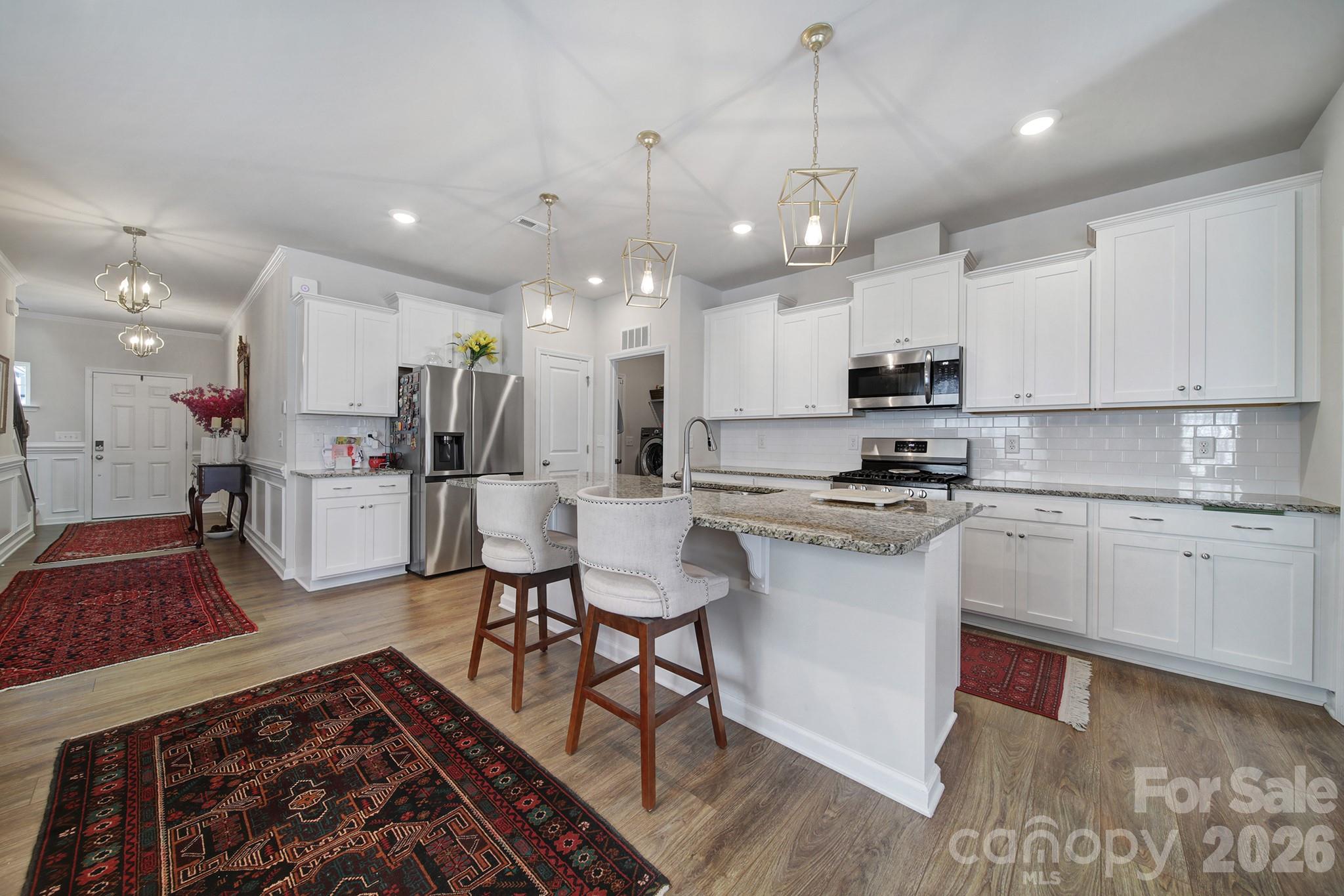 6521 Gopher Road Lancaster, SC 29720 - Photo 7 of 45 a kitchen with stainless steel appliances granite countertop a sink dishwasher a refrigerator and white cabinets with wooden floor