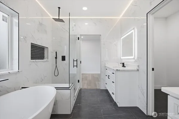 a bathroom with a tub sink and mirror