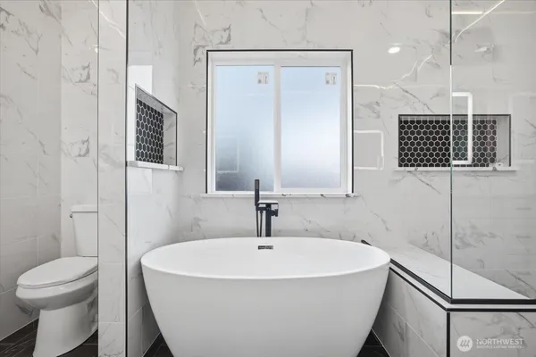 a bathroom with a sink a toilet a mirror and shower