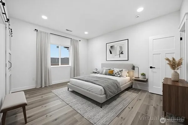 a bedroom with a large bed and a potted plant