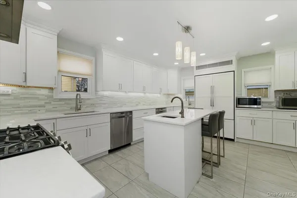 a kitchen with a sink a stove a refrigerator and cabinets