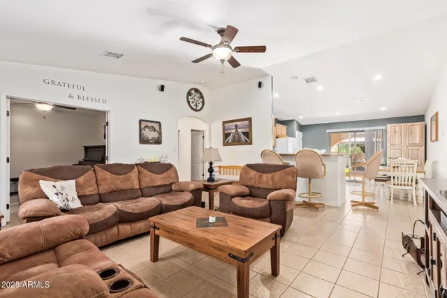 a living room with furniture a flat screen tv and a window
