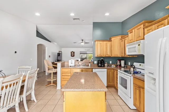 a kitchen with stainless steel appliances kitchen island granite countertop a sink and cabinets