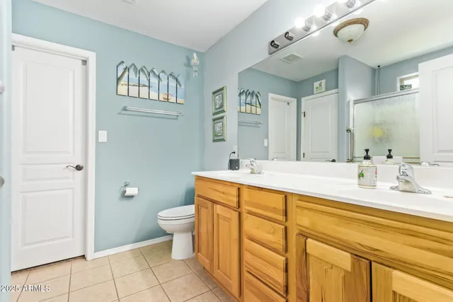 a en suite bathroom with a double vanity sink a mirror and a shower