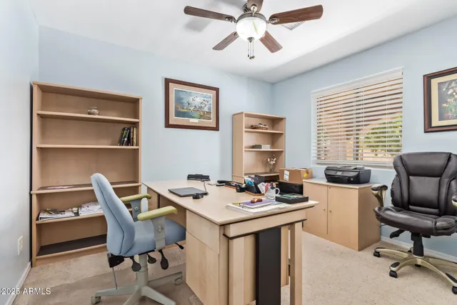 a view of a workspace with furniture and a window