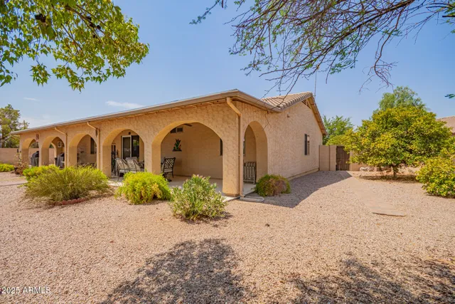 a view of a patio with table and chairs under an umbrella with a yard