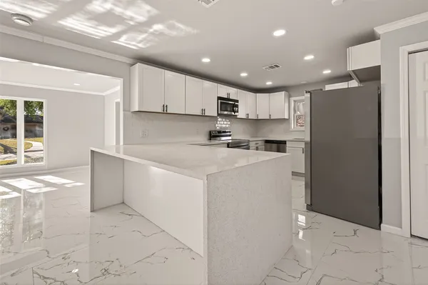 a kitchen with white cabinets stainless steel appliances and sink