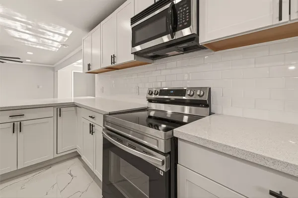 a kitchen with white cabinets stainless steel appliances and sink