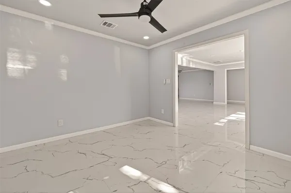 a view of a big room with wooden floor and windows