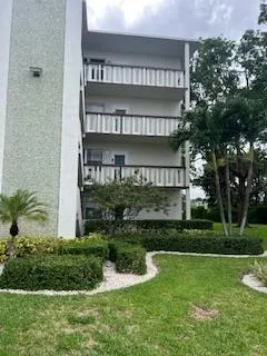 a view of a house with a yard and potted plants