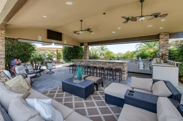 a view of a white house with large trees and wooden fence
