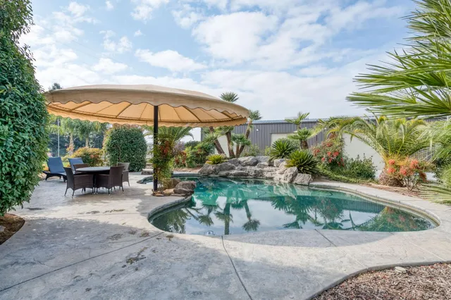an aerial view of a house with a garden and lake view