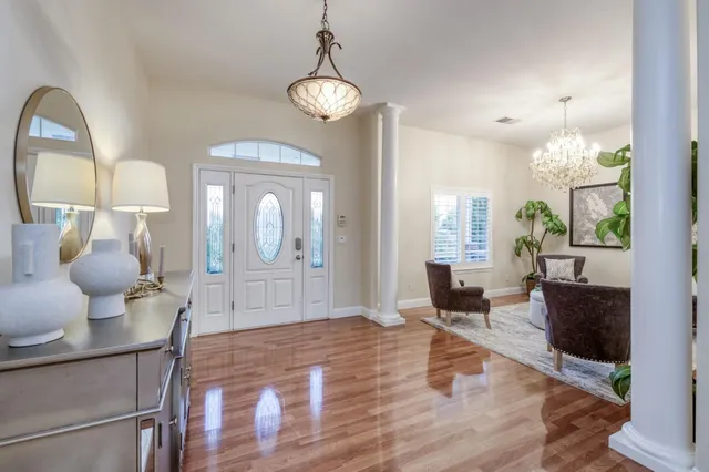 a living room with furniture kitchen view and a chandelier