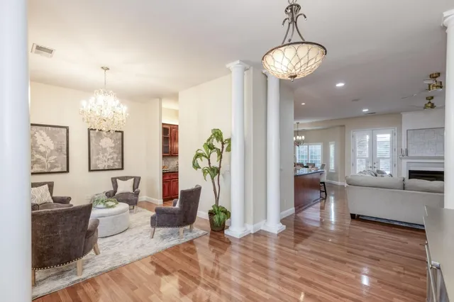 a living room with furniture a chandelier and a flat screen tv