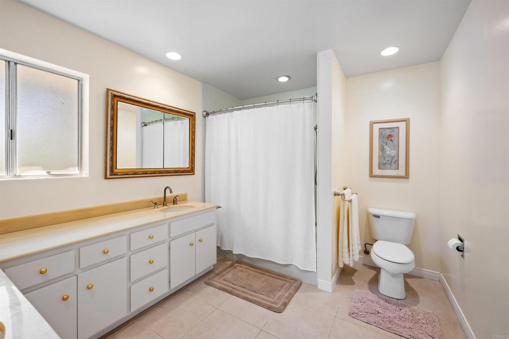 846 Val Sereno Drive Encinitas, CA 92024 - Photo 15 of 43 a spacious bathroom with a toilet a sink and a mirror