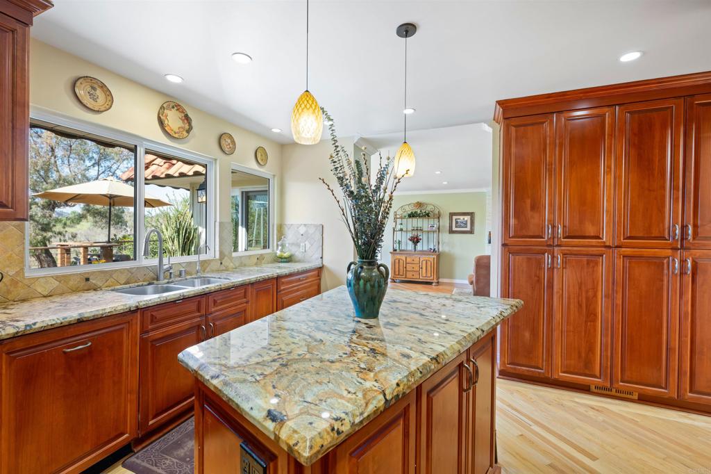 846 Val Sereno Drive Encinitas, CA 92024 - Photo 10 of 43 a kitchen with stainless steel appliances granite countertop wooden cabinets a refrigerator and a sink