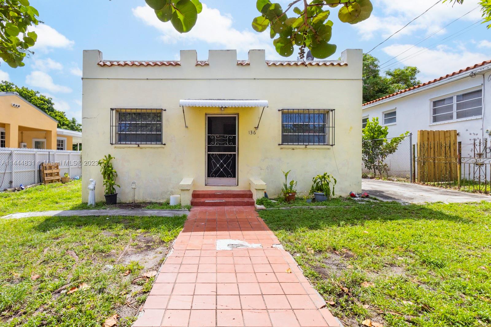 136 Northwest 25th Avenue Miami, FL 33125 - Photo 1 of 14 a front view of a house with a yard and garage