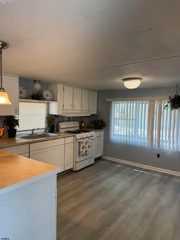 a kitchen with stainless steel appliances granite countertop a stove a sink and white cabinets