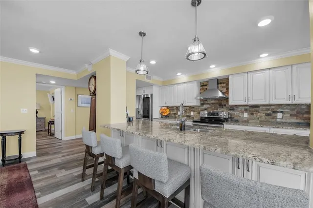 a kitchen with granite countertop white cabinets and stainless steel appliances