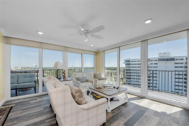 a living room with furniture kitchen view and a chandelier
