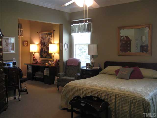 6213 Oconner Street Raleigh, NC 27617 - Photo 9 of 15 a bedroom with a bed and a chandelier