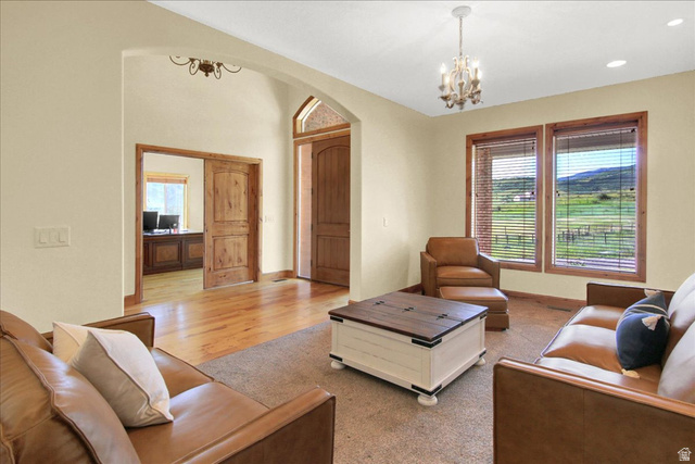 667 Hardscrabble Road Morgan, UT 84050 - Photo 14 of 51 Living room featuring suspended lighting, arched walkways, and light wood-style flooring