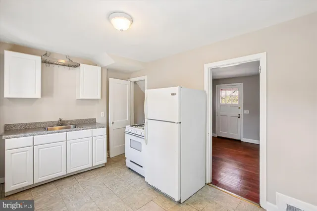 a kitchen with white cabinets and white appliances