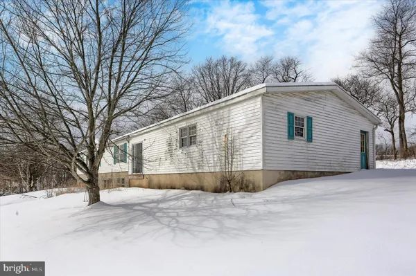 a view of a dry yard covered with snow in the background