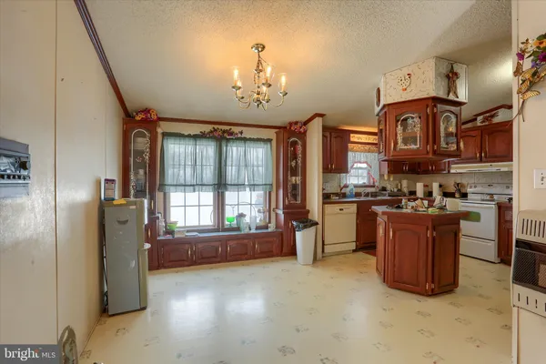 a kitchen with granite countertop a sink cabinets stainless steel appliances and a window