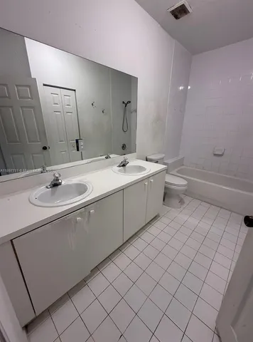 a bathroom with a sink toilet and mirror