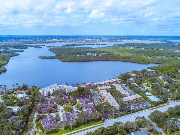 an aerial view of ocean and residential houses with outdoor space