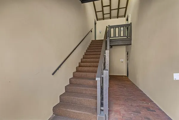 a view of staircase with railing and white walls