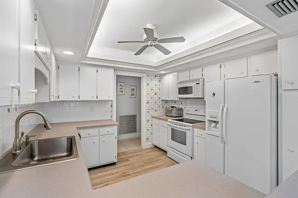 a kitchen with stainless steel appliances granite countertop a sink and a refrigerator