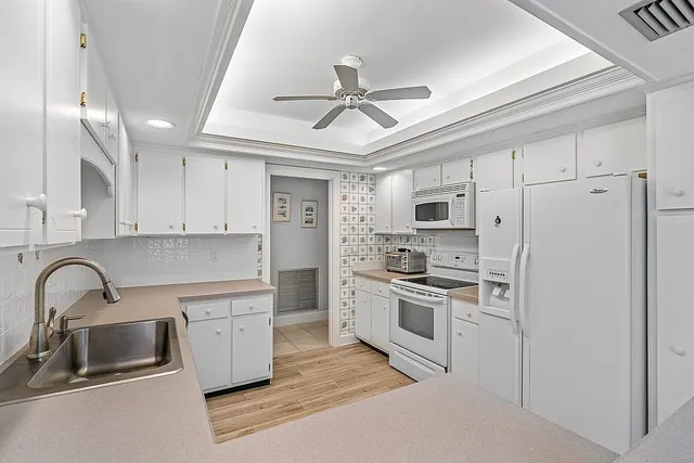 a kitchen with stainless steel appliances granite countertop a sink and a refrigerator