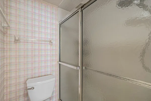 a white toilet sitting next to a shower