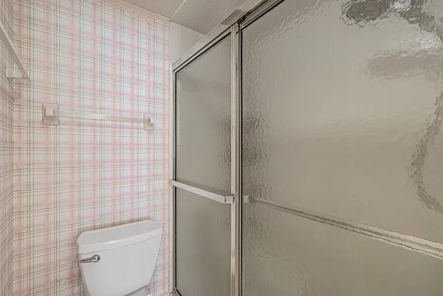 a white toilet sitting next to a shower