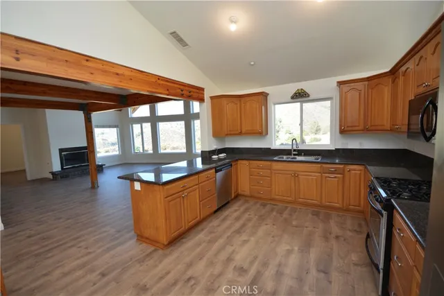 a large kitchen with wooden floors and stainless steel appliances