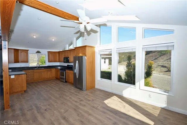 a kitchen with stainless steel appliances kitchen island granite countertop a refrigerator and a sink