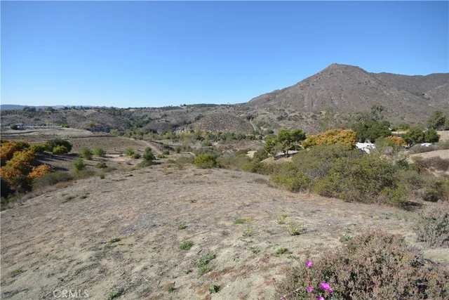 a view of a dry yard with mountains in the background