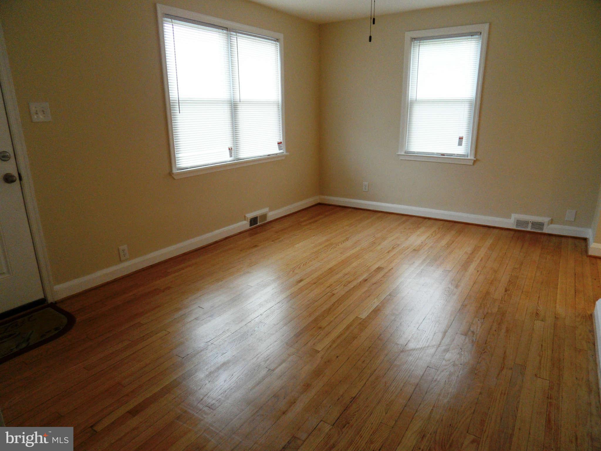7019 Brompton Road Baltimore, MD 21207 - Photo 3 of 26 an empty room with wooden floor and windows