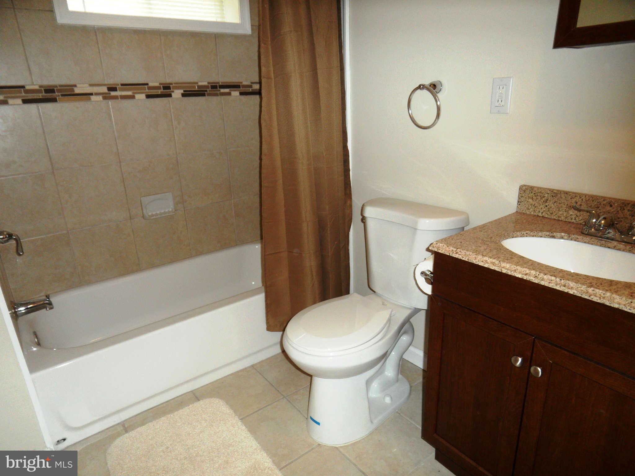7019 Brompton Road Baltimore, MD 21207 - Photo 22 of 26 a bathroom with a granite countertop sink toilet and shower