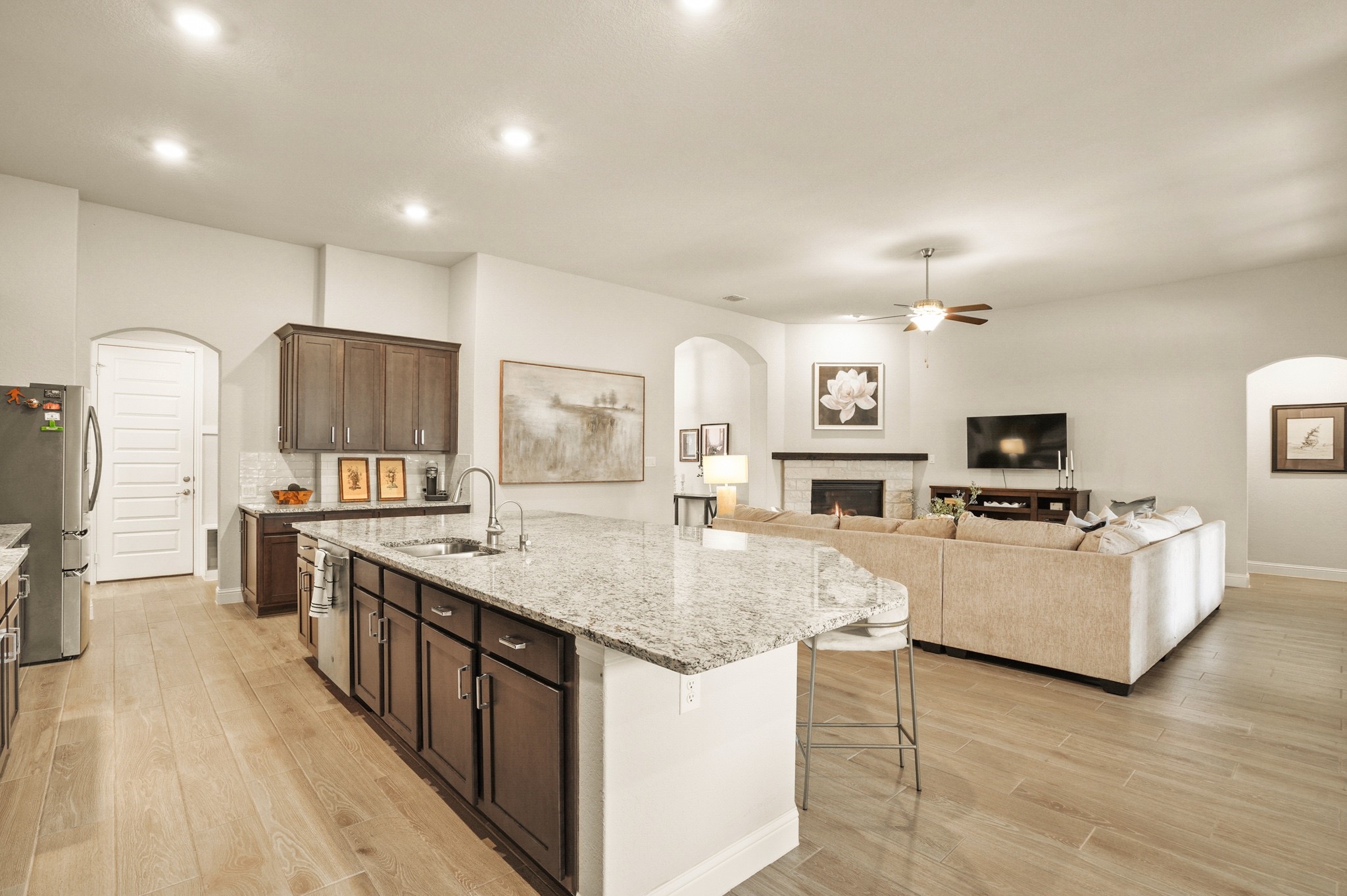 29411 Kearney Ridge Boerne, TX 78015 - Photo 17 of 34 a kitchen with stainless steel appliances granite countertop a stove top oven a sink dishwasher and a refrigerator with wooden floor