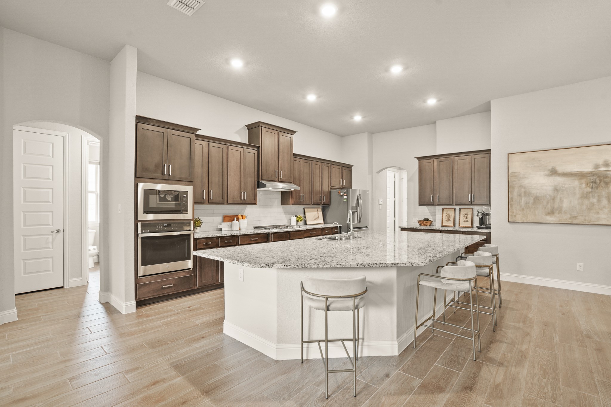 29411 Kearney Ridge Boerne, TX 78015 - Photo 4 of 34 a large kitchen with kitchen island a stove a refrigerator and a sink with wooden cabinets